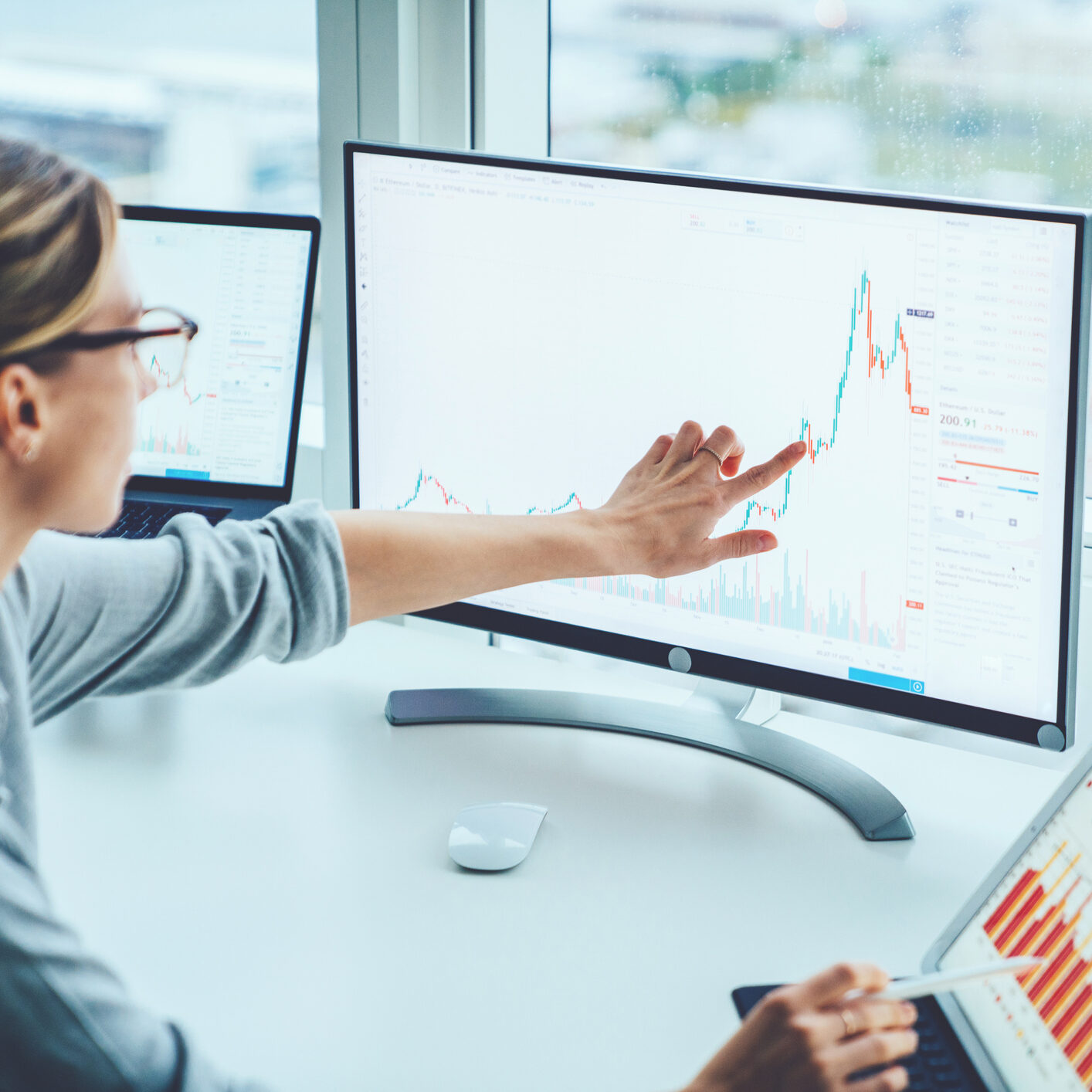 Business woman study financial market to calculate possible risks and profits.Female economist accounting money with statistics graphs pointing on screen of computer at desktop. Quotations on exchange